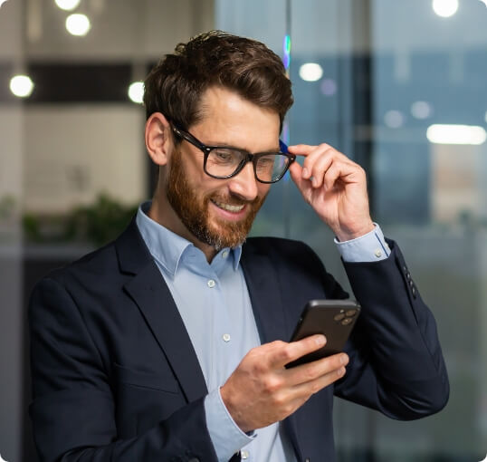 Man with Glasses Smiling at Phone
