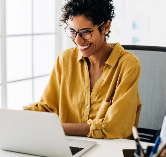 Woman Smiling at Laptop