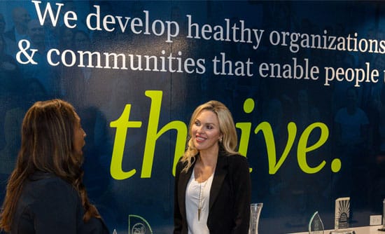 Employees chatting in front of mission statement